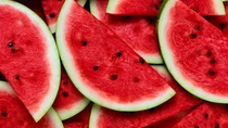 A large number of cut slices of ripe watermelon.Texture or background