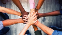 Close up view of young business people putting their hands together. Stack of hands. Unity and teamwork concept.